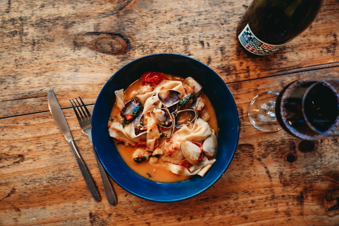Seafood pasta dish with wine on wooden table