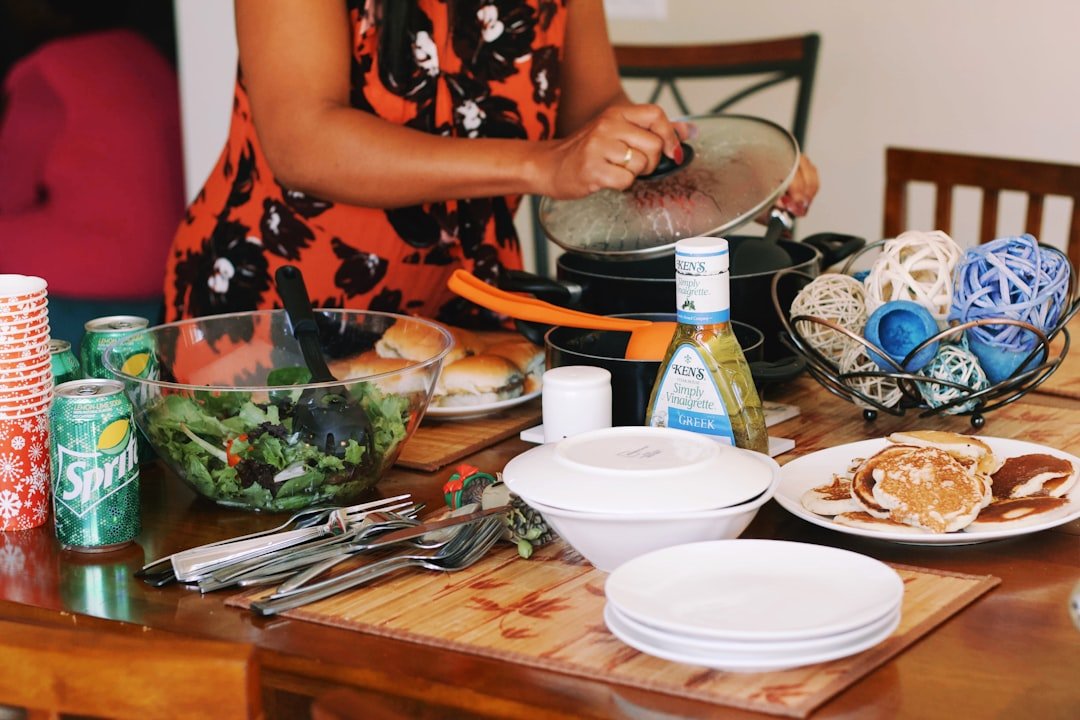 a woman in an orange dress preparing food on a wooden table