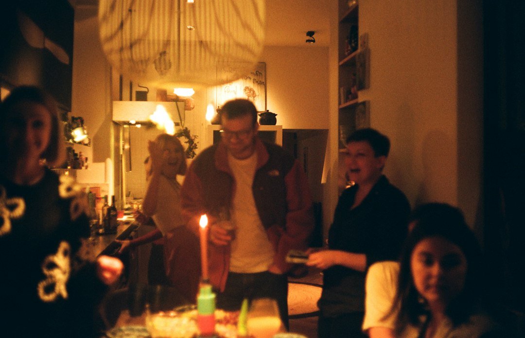People gathered around a table with a lit candle